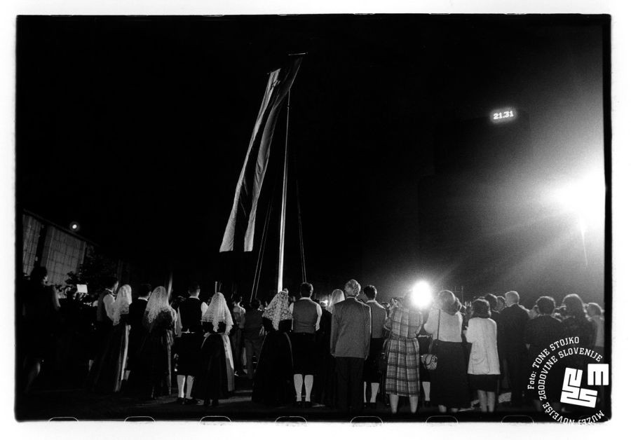 Raising of Slovenian Flag, a crowd of people, some in national costumes.