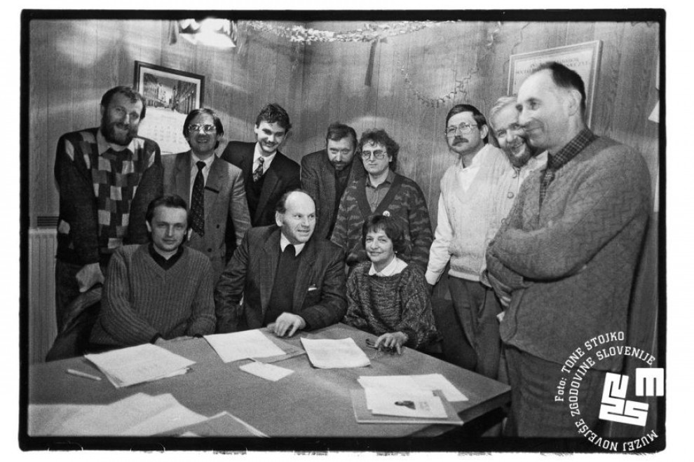 Sedijo Andrej Magajna, Jože Pučnik, Katja Boh, Ivan Oman. Stojijo za njimi Dušan Plut, Rajko Pirnat, Marjan Podobnik, Dimitrij Rupel, Hubert Požarnik, Leo Šešerko.