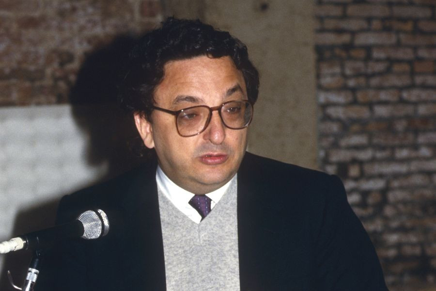 Gianni de Michelis stoji pred mikrofonom.