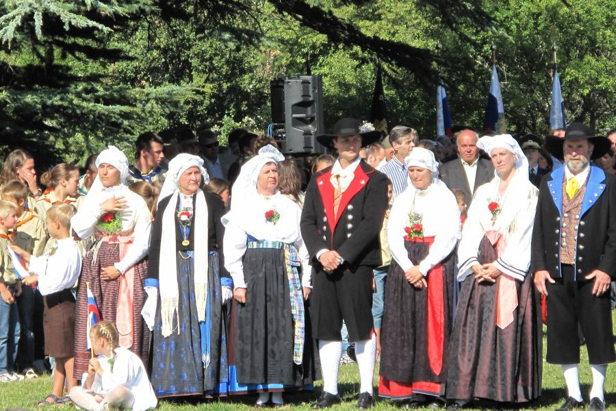 skupina oseb stoji, vsi so oblečeni v ljudske noše