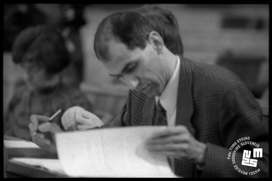 Janez Janša pregleduje papirje v skupščini.