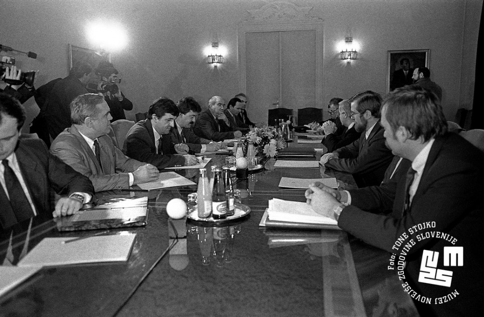Člani predsedstev sedijo za mizo.
