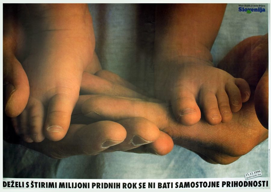 Roke odraslega držijo noge majhnega otroka.