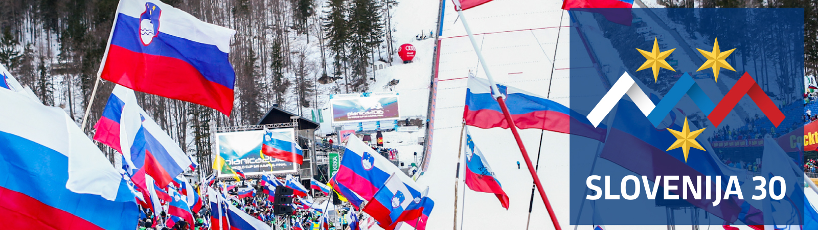 Občinstvo v zasneženi Planici drži slovenske zastave.