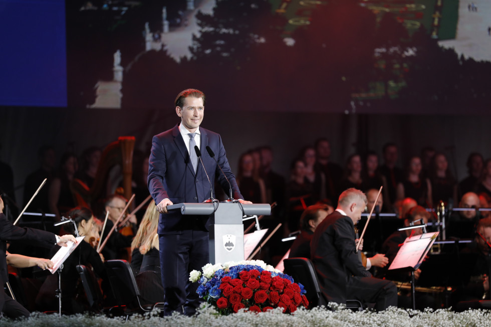 Predsednik Republike Avstrije Sebastian Kurtz stoji za govorniškim pultom.