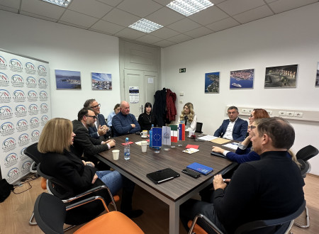 Udeleženci sestanka si sedijo okoli mize