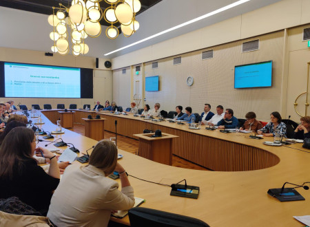 Udeleženci posveta sedijo za mizo.