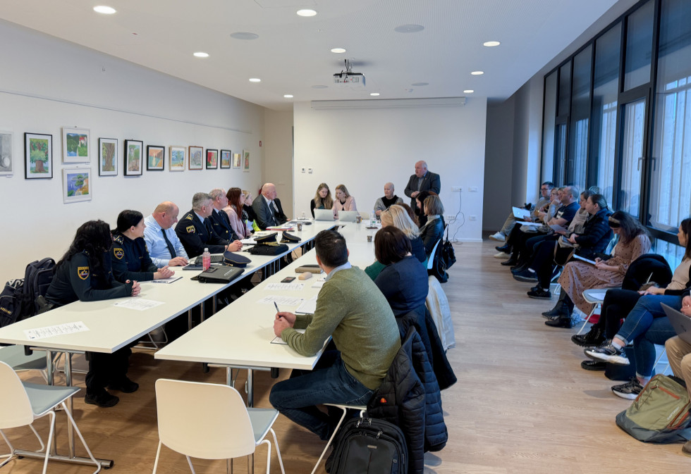 Udeleženci sedijo za mizo