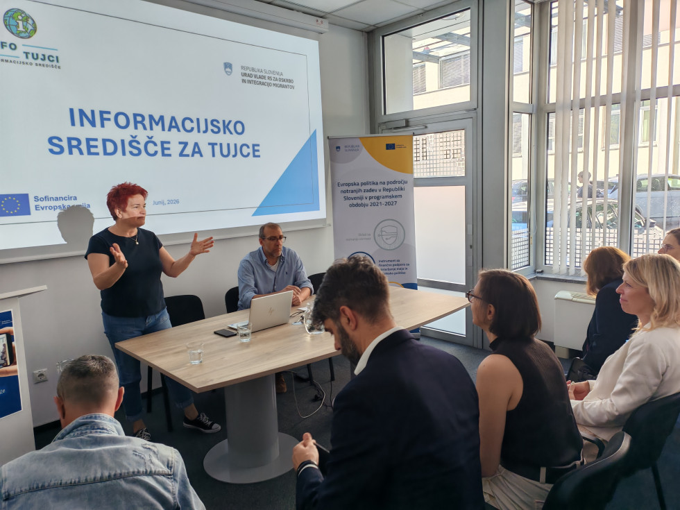 Ženska, vodja informacijskega središča, govori pred množico