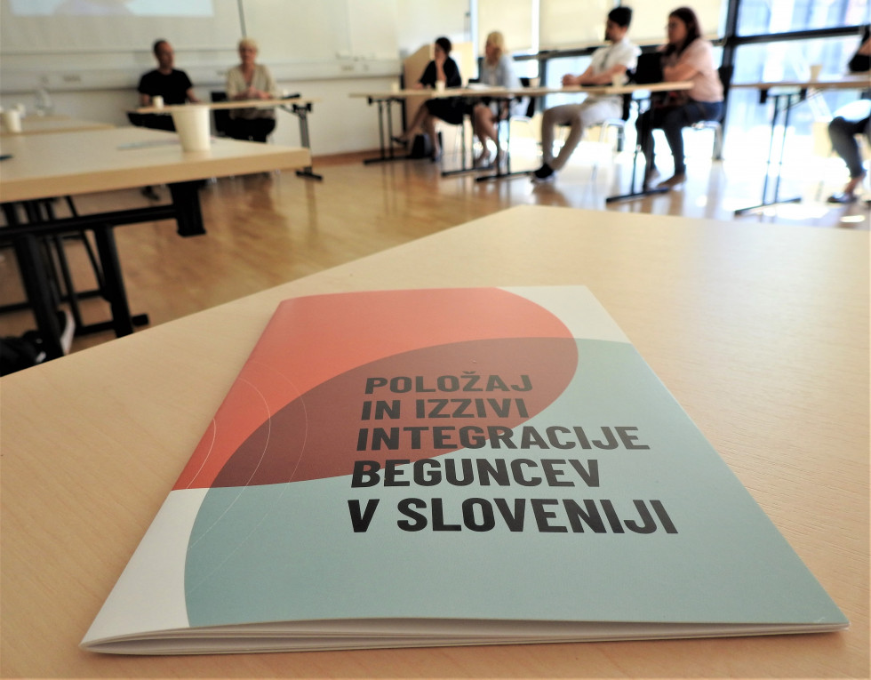 Brošura na mizi med srečanjem na temo vključevanja beguncev