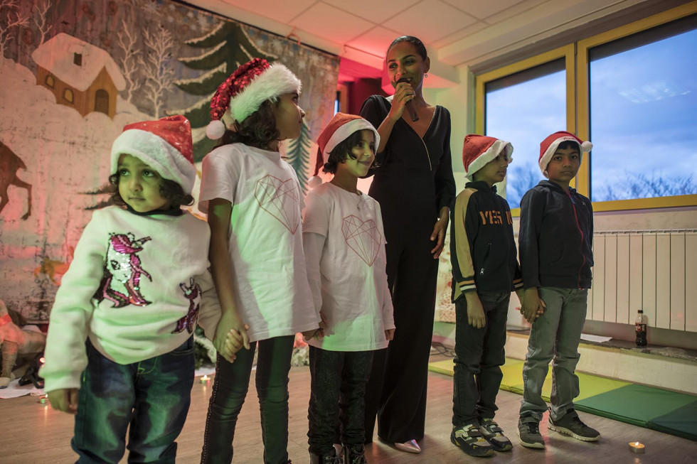 Pevka Irena Yebuah Tiran in otroci z božičkovimi kapicami