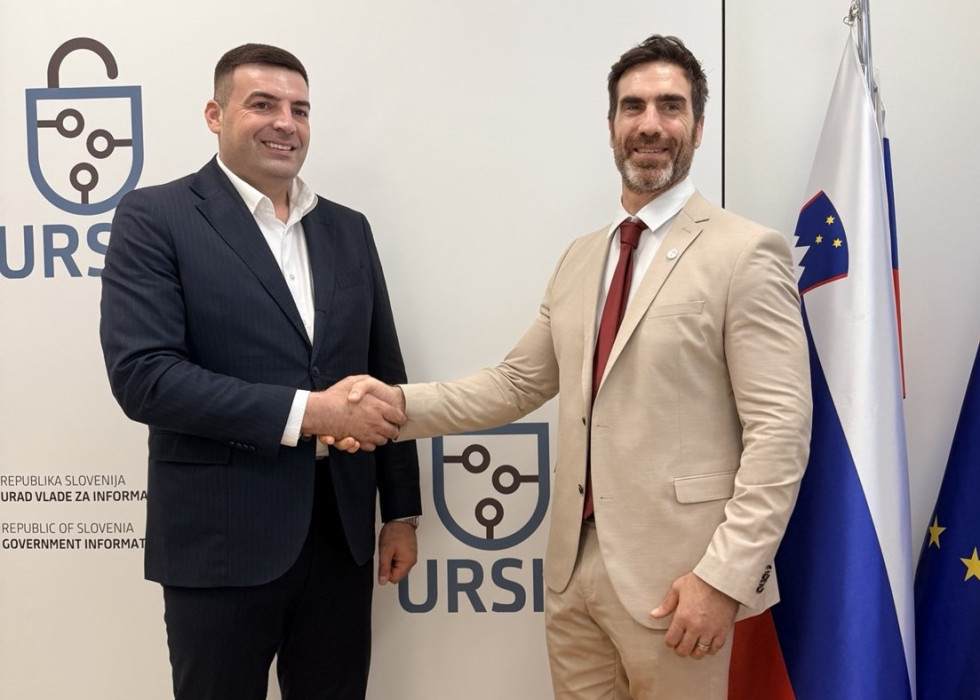 Moška v poslovnih oblačilih si ob uradnem srečanju segata v roke.