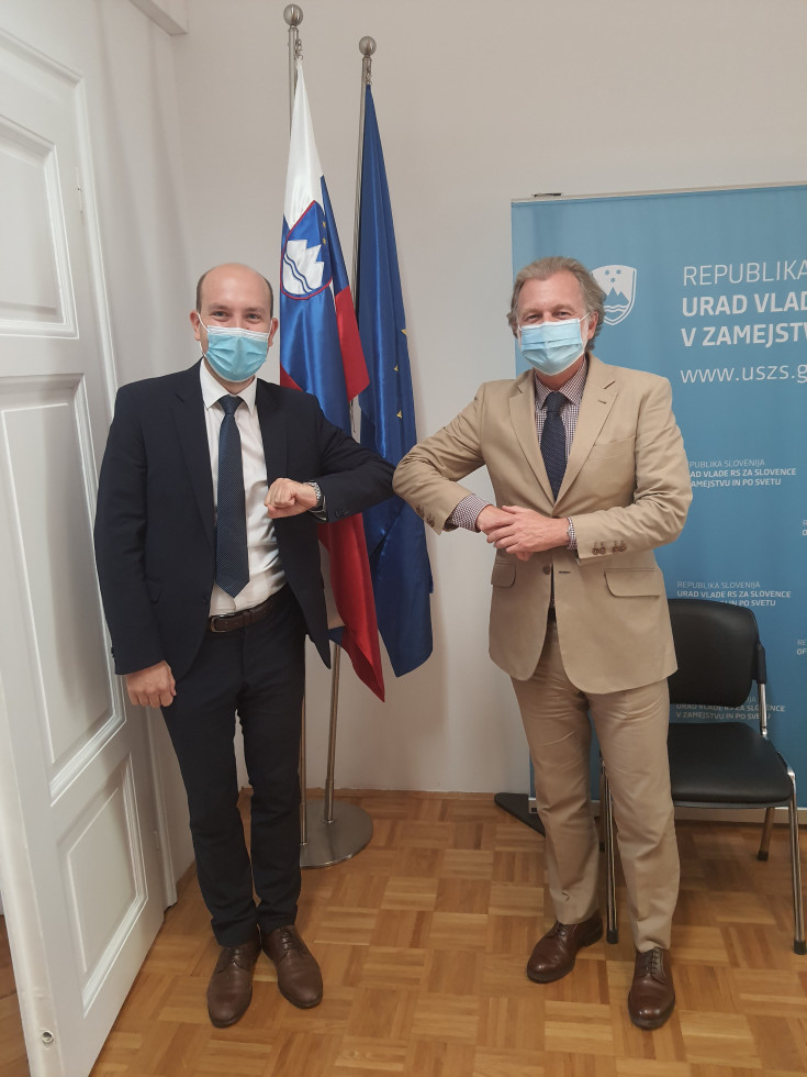 Stojita pred zastavami inse rokujeta s komolici. 