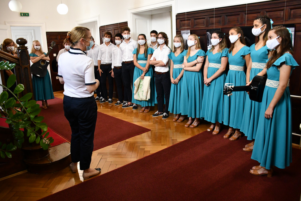 Med pogovorom, ministrica slikana v hrbet, mladi iz Argentine - dekleta v modrih oblekah, fantje v belih srajcah.