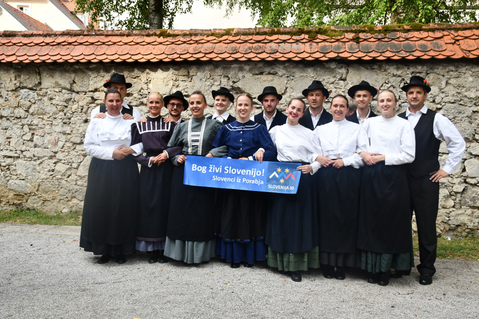 Po nastopu, v rokah napis "Bog živi Slovenijo! Slovenci iz Porabja."