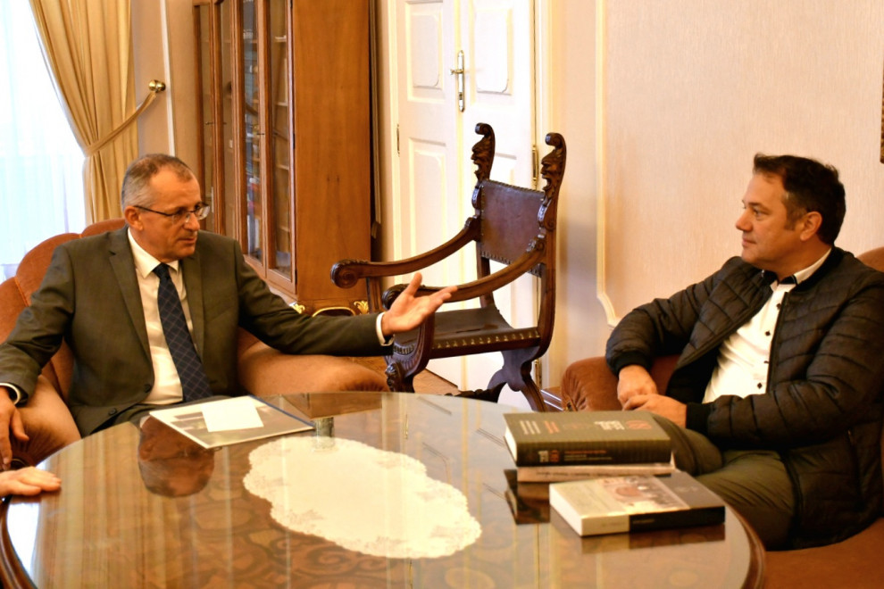 Dr. Peter Štih in Matej Arčon sedita in se pogovarjata.