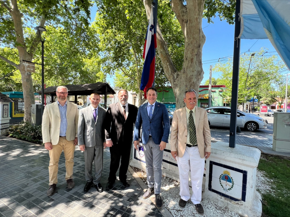 Pavel Šmon, Alain Brian Bergant, Tine Šmon, Matej Arčon, Jože Šmon stojijo pred slovensko in argentinsko zastavo, ki se nahajata na Trgu Republike Slovenije v Mendozi.