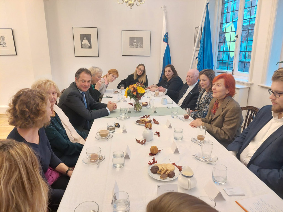 Minister s predstavniki slovenske skupnosti. Sedijo za mizo.