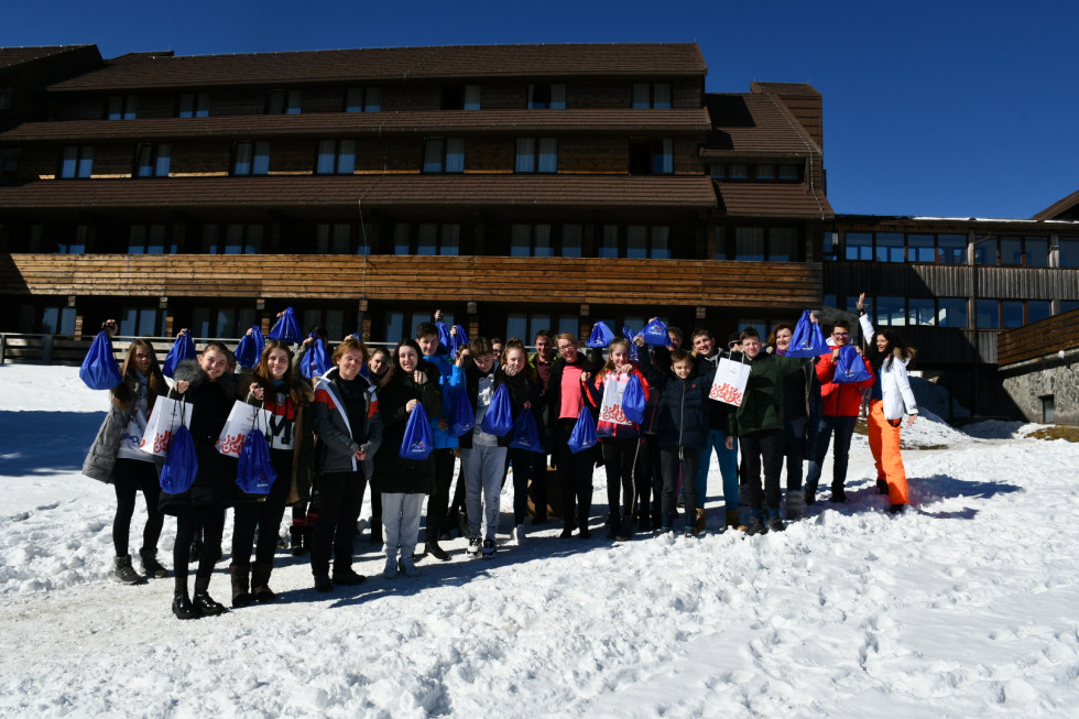 Miistrica z učenci in učitelji na snegu pred hotelom.