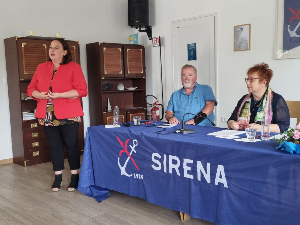 Državna sekretarka Vesna Humar govori in stoji. Rudi Pavšič in senatorka Tatjana Rojc sedita. Pred njima napis Sirena.
