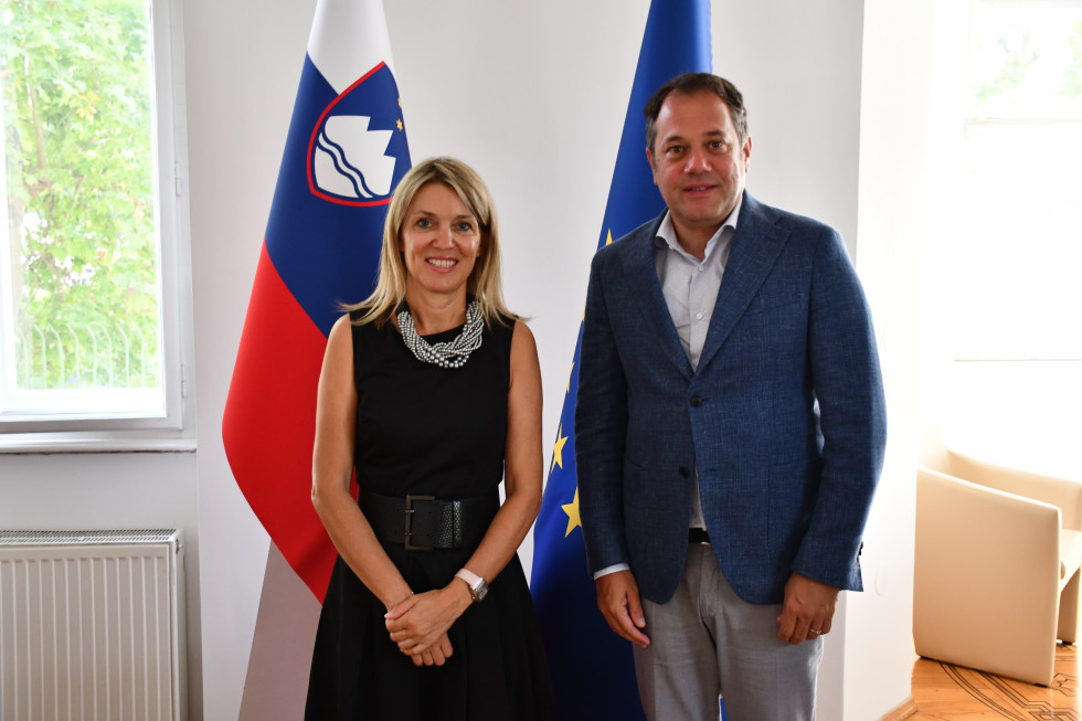 Matej Arčon in Barbara Uranjek pred slovensko in evropsko zastavo.