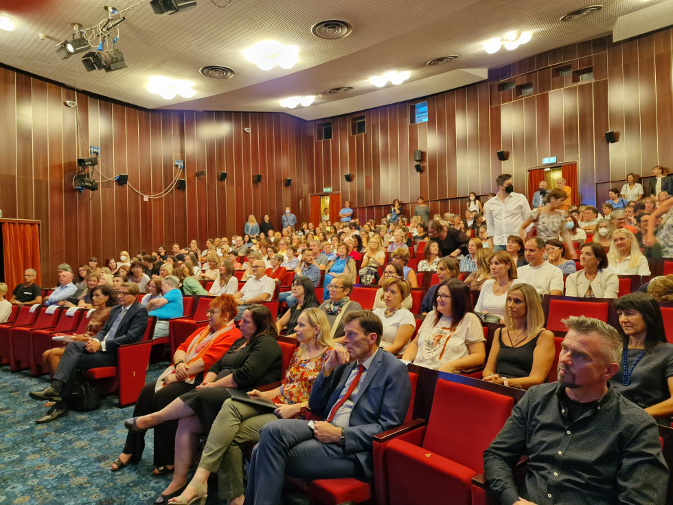 Udeleženci. V ospredju državna sekretarka Humar in senatorka Rojc. Sedijo v dvorani kulturnega doma.