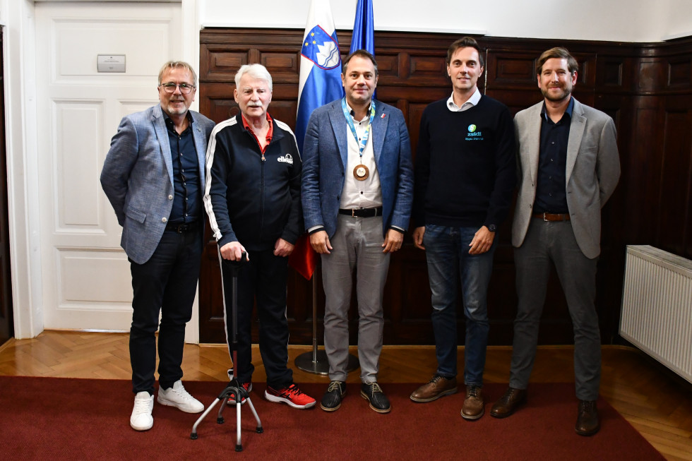 Marjan Velik, Ivan Peterlin, Matej Arčon, Evgen Ban, Marko Loibnegger stojijo v avli urada, za njimi slovenska in evropska zastava.