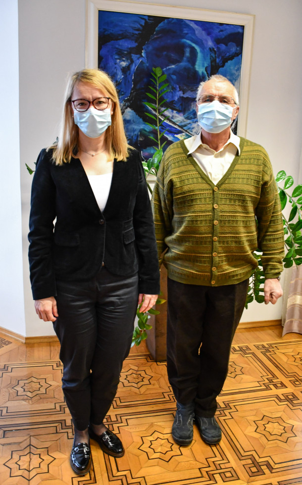 ministrica in dr. Rajšp stojita pred modro umetiško sliko in fikusom.