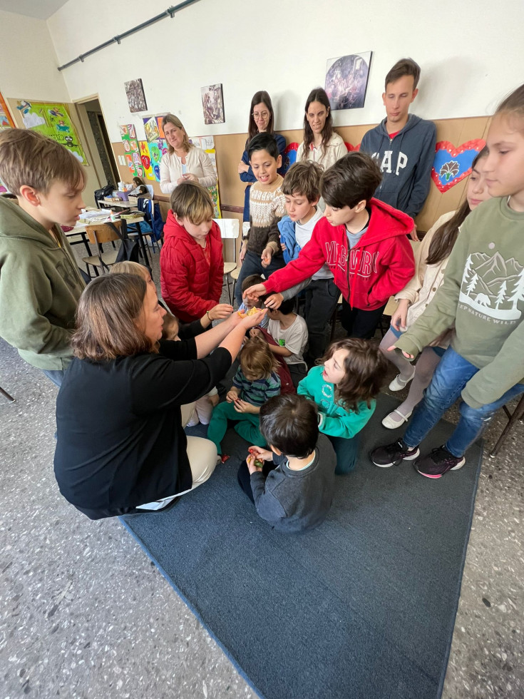 Državna sekretarka z otroci v Jegličevi šoli. Med tem ko otrokom deli bombone.