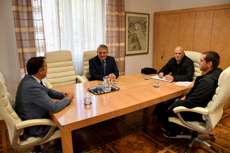Minister Arčon s sogovorniki.Sedijo za mizo.