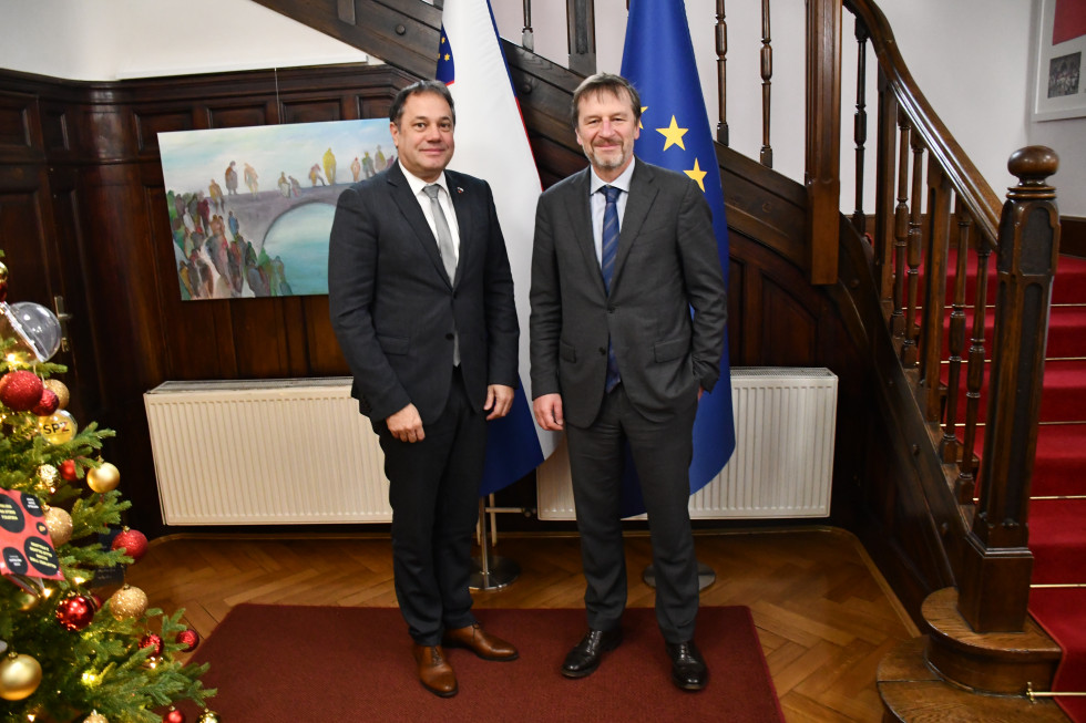 Matej Arčon in Sławomir Tokarski pred slovensko in evropsko zastavo.