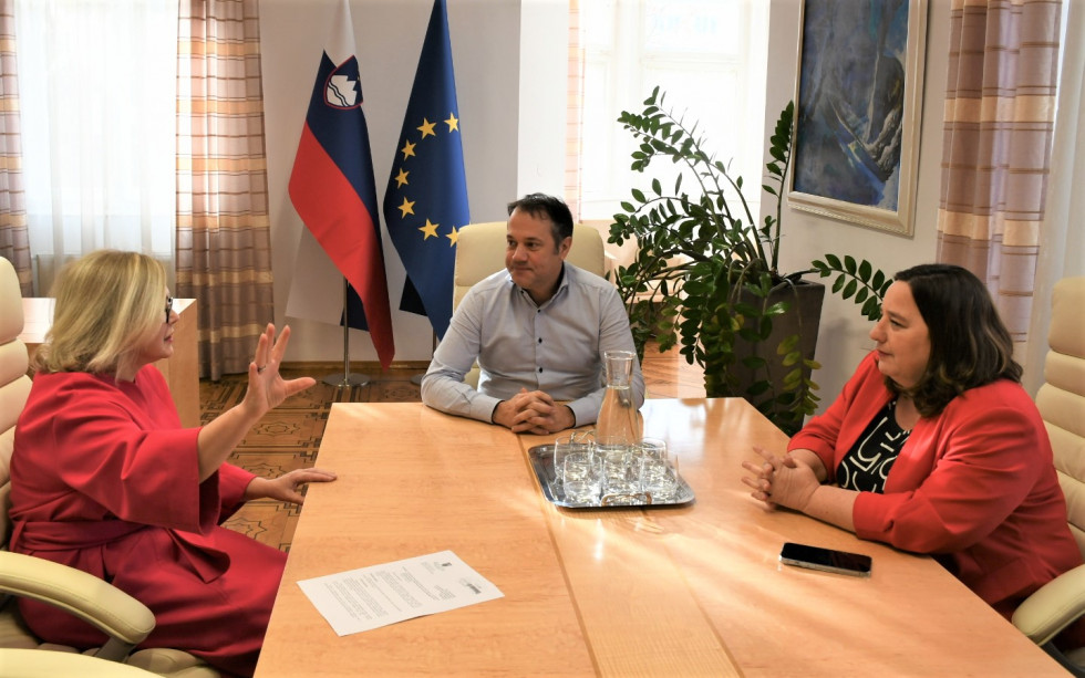 Barbara Antolić Vupora, Matej Arčon, Vesna Humar sedijo za mizo in se pogovarjajo. V ozadju slovenska in evropska zastava.