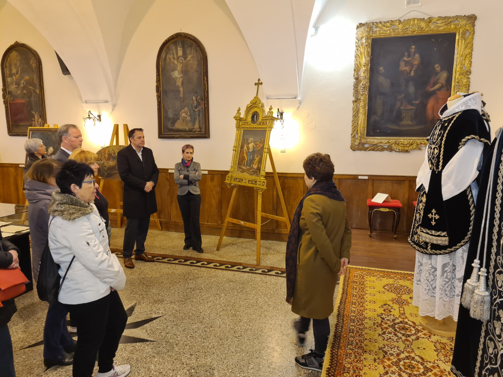 Minister Arčon v Goriškem muzeju. Stoji v prostoru in si ogleduje razstavo.
