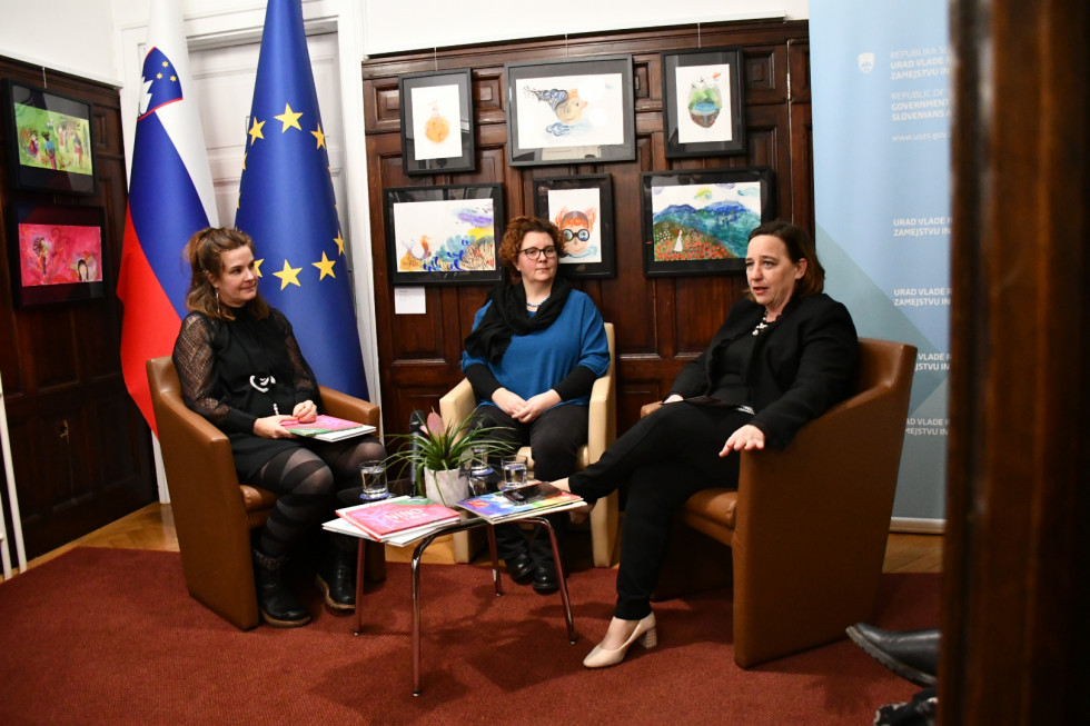 Dunja Jogan, Katerina Kalc in Vesna Humar. Sedijo, za njimi na desni slovenska in evropska zastava, na sredini ilustracije.