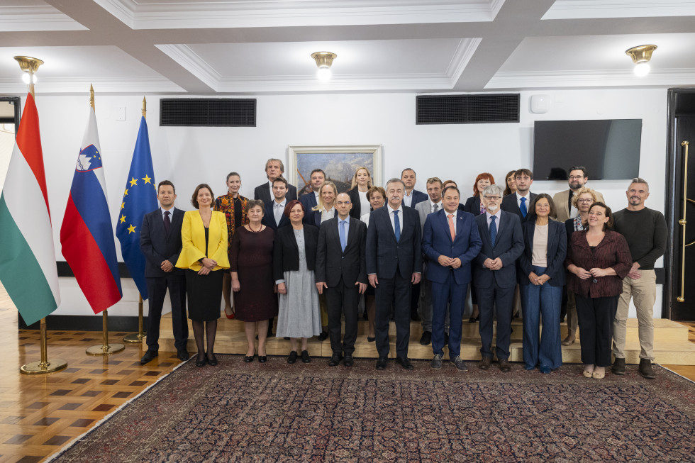 Minister Matej Arčon, ministerial commissioner Ferenc Kalmárand the Slovenian and Hungarian delegation. Group photo, Hungarian, Slovenian and European flags on the side.