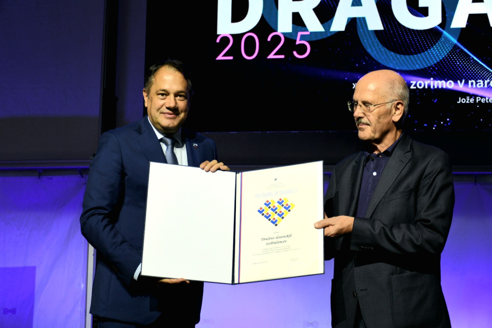 Minister in predsednik društva držita priznanje.