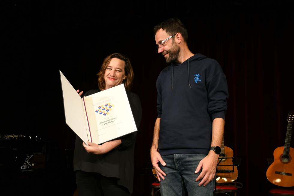 Državna sekretarka v rokah drži priznanje. 