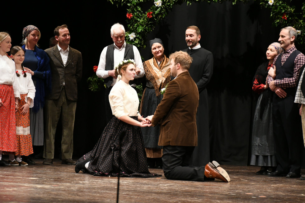 igralca klečita pri poroki, okoli svatje.