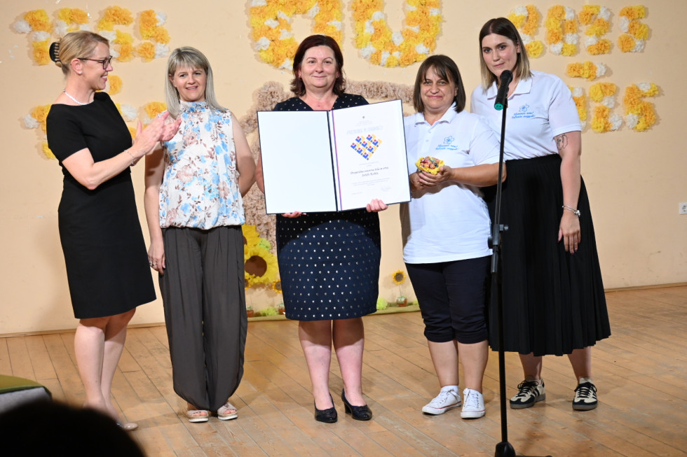 Ministrica z ravnateljico, vzgojiteljicami. S priznanjem.